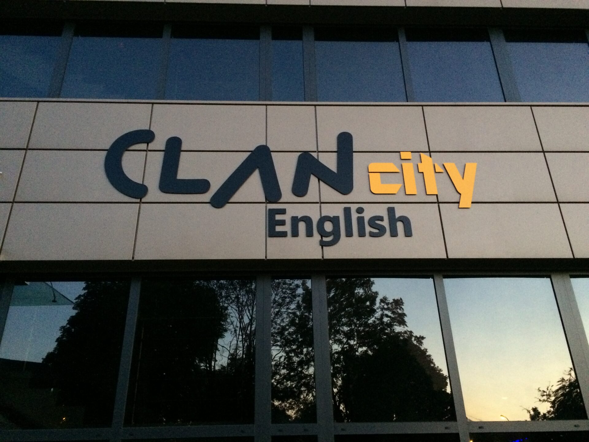 ClanCity English - wejście do nowej siedziby w Zabrzu. Duże litery wykonane z Dibond - czarny oraz żółty - na panelowej elewacji budynku.